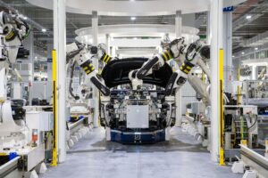 Robots assembling car in factory production line.