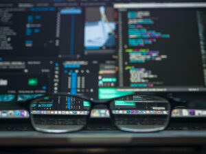 Glasses on laptop showing code on screen