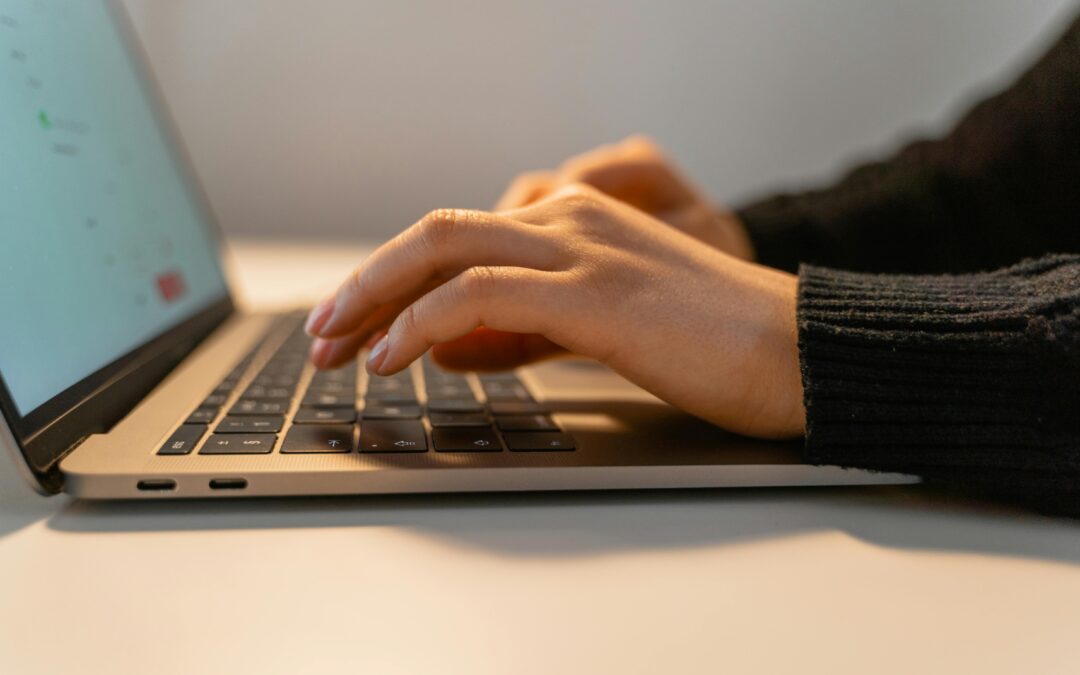 Person typing on laptop keyboard