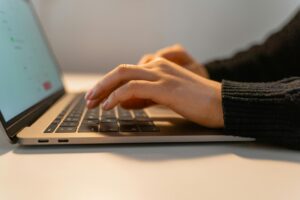 Person typing on laptop keyboard
