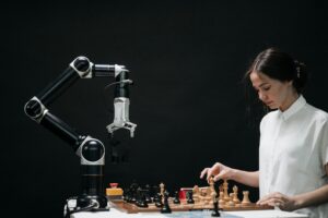 Robot arm and woman playing chess.