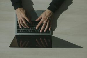 Hands typing on a laptop keyboard.