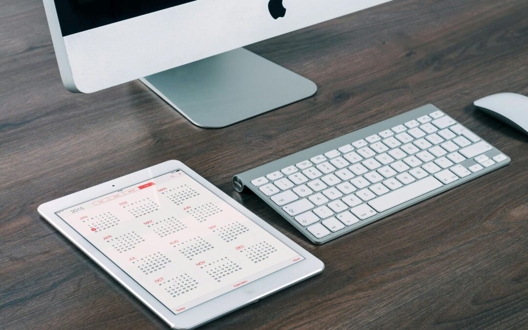iMac, tablet with calendar, keyboard on desk